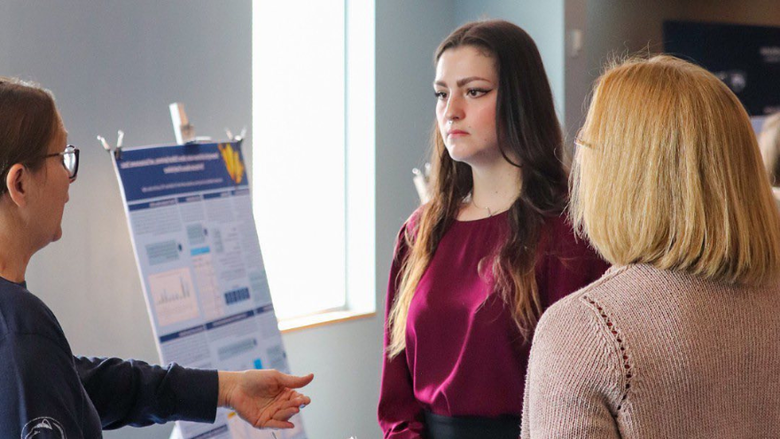 A student speaking with two judges in a classroom 