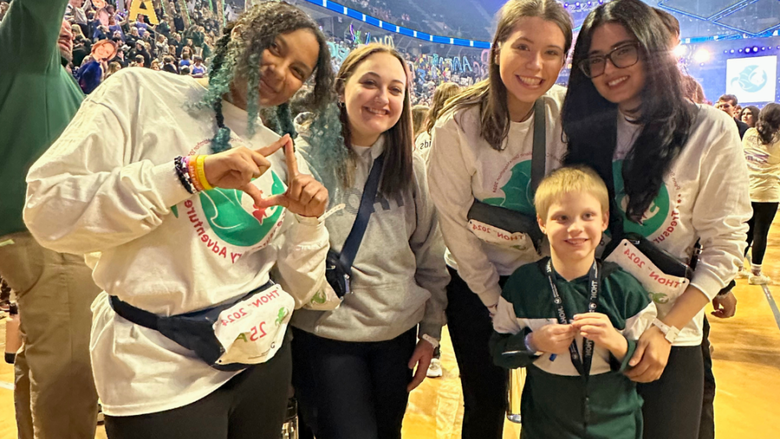 four young women and a young boy smiling at the camera 