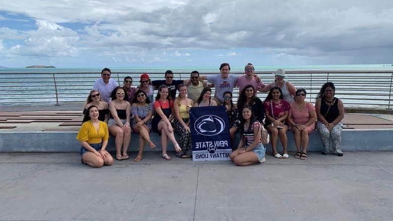 group of students and faculty in front of an ocean in Puerto Rico