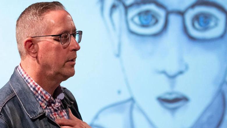 man in front of a graphic that says The Anxiety Project